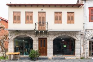 a white building with brown doors and windows at Muses old town ioannina Calliope in Ioannina