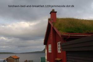 a red house with a grass roof on top of it at Bed & Breakfast Torshavn in Tórshavn
