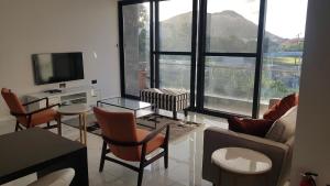 a living room with a couch and chairs and a tv at One Rodney Heights Condominiums in Gros Islet