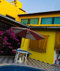 - une table et un parasol à côté de la piscine dans l'établissement Ruta Del Sol, à Mossoró