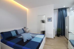 Un dormitorio con una cama azul y blanca en una habitación en Solli Rooms, en Palermo