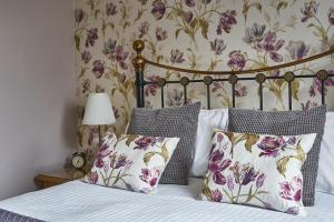 a bedroom with a bed with purple and white pillows at Haisthorpe Guest House in Windermere