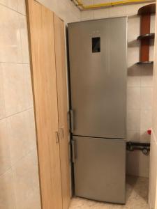 een roestvrijstalen koelkast in een keuken naast een deur bij Microapartament Campulung Moldovenesc in Câmpulung Moldovenesc