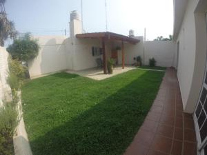 einen Hinterhof mit einer Liegewiese mit einem Pavillon in der Unterkunft Casa Esquina - Barrio Palermo - Zona Anfiteatro in Villa María
