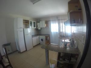 eine Küche mit weißen Geräten und einer Arbeitsplatte in der Unterkunft Casa Esquina - Barrio Palermo - Zona Anfiteatro in Villa María