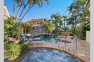 - une piscine avec un bain à remous dans la cour dans l'établissement Haven on Noosa Hill - sunset views, pools, spa, à Noosa Heads