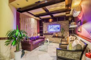 a living room with a purple couch and a tv at Al Muhaidb Al Malaz - Al Jamiah in Riyadh