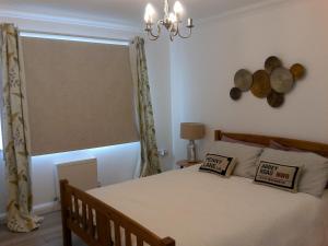 a bedroom with a bed with a window and a chandelier at Two bedroom London Luxury Apartment in London