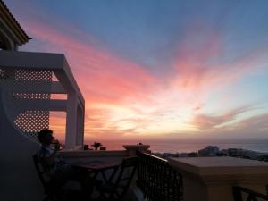 a man sitting on a balcony watching the sunset at Dream View in Adeje
