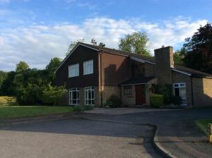a brick house with a driveway in front of it at Cobblestones in Benington