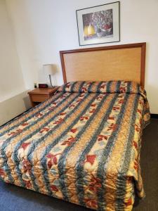 a bed in a hotel room with a quilt on it at Apple Tree Inn in Spokane