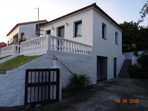 une maison blanche avec une clôture devant elle dans l'établissement Quinta da Maria, à Horta