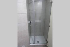 La salle de bains est pourvue d'une douche avec une porte en verre. dans l'établissement Luminous Central Apartment, à Porto
