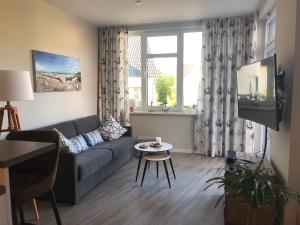 a living room with a couch and a table at Ferienwohnung MeerZeitPerle in Glowe