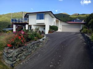 a house with a stone wall and a driveway at Moana View in Picton