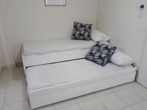 un sofá blanco con almohadas en una habitación en Cómodo y versátil en casco histórico en Salta