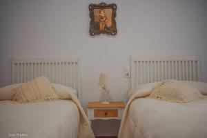 a bedroom with two beds and a mirror on the wall at Santa Angela de la Cruz in Peñaflor