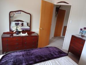 a bedroom with a dresser and a mirror on a dresser at Moana View in Picton