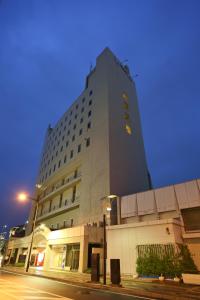een hoog gebouw met een bord aan de zijkant bij Bell's Inn Tsuchiura in Tsuchiura