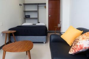 uma sala de estar com um sofá, uma cama e mesas em MiniApartamentos GRAN IMPERIAL PREMIUM em Tumbes