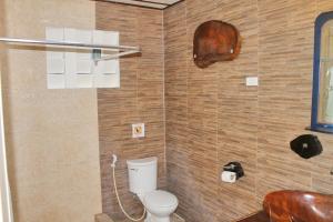 a bathroom with a toilet in a room at Deep Forest Garden Hotel in Puerto Princesa City