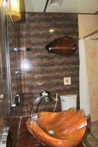 y baño con ducha y bañera de madera. en Deep Forest Garden Hotel, en Puerto Princesa City