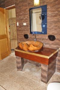 
a wooden table with a bowl of food on top of it at Deep Forest Garden Hotel in Puerto Princesa City
