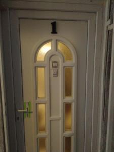 a white door with a cross on top of it at Grey Orchid Apartment - studio in Budapest