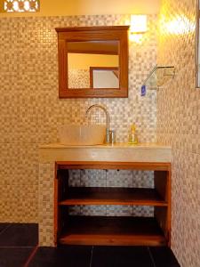 a bathroom with a sink and a mirror at Two Brothers Bungalows in Gili Meno