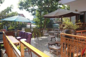 an outdoor patio with tables and chairs and umbrellas at Hoi An Golden Horse Villa in Hoi An