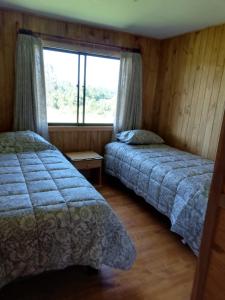 Hospedaje Las Animas Valdivia في فالديفيا: غرفة نوم بسريرين ونافذة