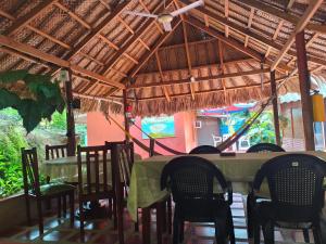 a restaurant with a table and chairs and a ceiling at Hostal Recuerdos del Tayrona in El Zaino