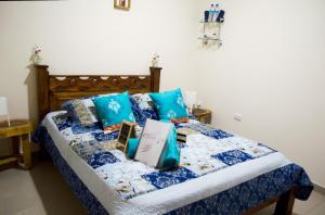 a bedroom with a bed with blue pillows at Guesthouse Casa Lapa2 in Alajuela