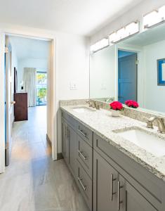 łazienka z 2 umywalkami i dużym lustrem w obiekcie Beach Living at Villas Pappagallo (BLPD) w mieście West Bay