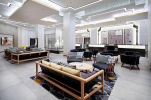 a lobby with couches and tables and chairs at Citadines Namba Osaka in Osaka