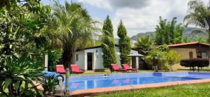 a villa with a swimming pool in front of a house at Hotel Boutique Bacaanda in Tepoztlán