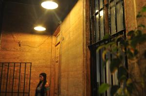 a woman walking down a hallway at night at Loft Histórico Manuel Rodriguez in Iquique