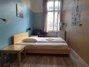 1 dormitorio con cama, mesa y ventana en Pension I, en Berlín