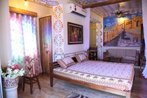een slaapkamer met een bed en een schilderij aan de muur bij HERITAGE ABOVE 1 in Jaipur