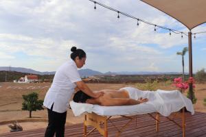 a woman is giving a man a massage on a bed at Villa Victoria, Valle de Guadalupe in Valle de Guadalupe