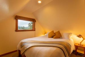 Schlafzimmer mit einem Bett und einem Fenster in der Unterkunft Kahere Retreat in Franz Josef