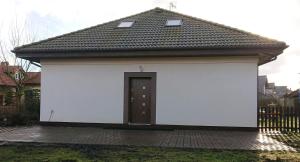 a white building with a door and a roof at Widokowa Apartament in Szczecin