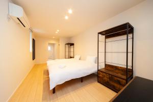 a bedroom with a white bed and a mirror at VILLA ROCHALIE by Hakuba Hotel Group in Hakuba