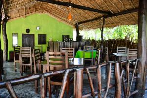 a restaurant with tables and chairs and a green wall at Little Sunshine Guest House & Restaurant in Tangalle +75 photos