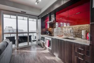 a kitchen with red cabinets and a large window at Luxury Adventure CN Tower/MTCC/Scotiabank Arena in Toronto