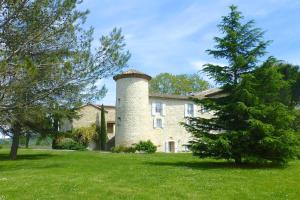 een gebouw met een toren aan de zijkant van een tuin bij Gîtes Château de la Selve in Grospierres