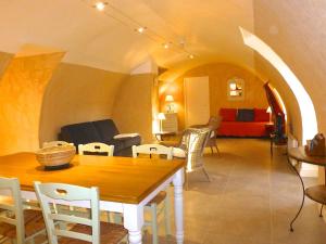 een woonkamer met een tafel, stoelen en een bank bij Gîtes Château de la Selve in Grospierres