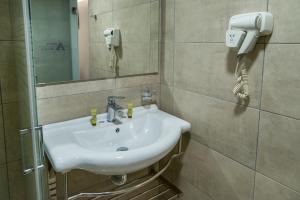 比雷埃夫斯的住宿－阿爾戈酒店，一间带水槽的浴室和墙上的一部电话