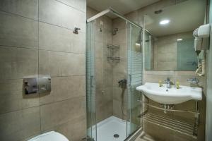 
a bathroom with a shower, sink, and toilet at Argo Hotel Piraeus in Piraeus
