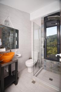a bathroom with a toilet and a glass shower at Entechnos Living in Skiathos